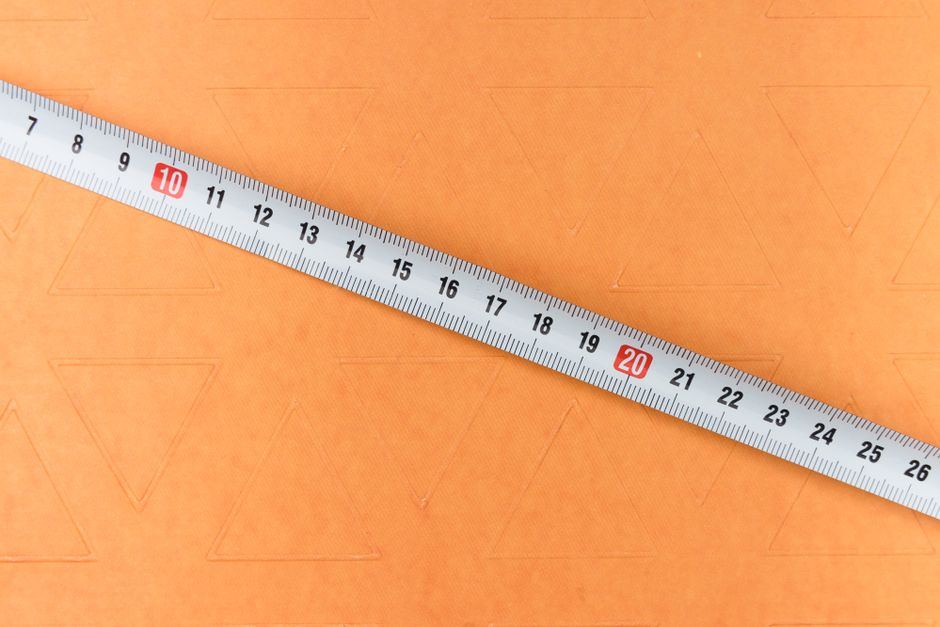 A tape measure laid across an orange surface